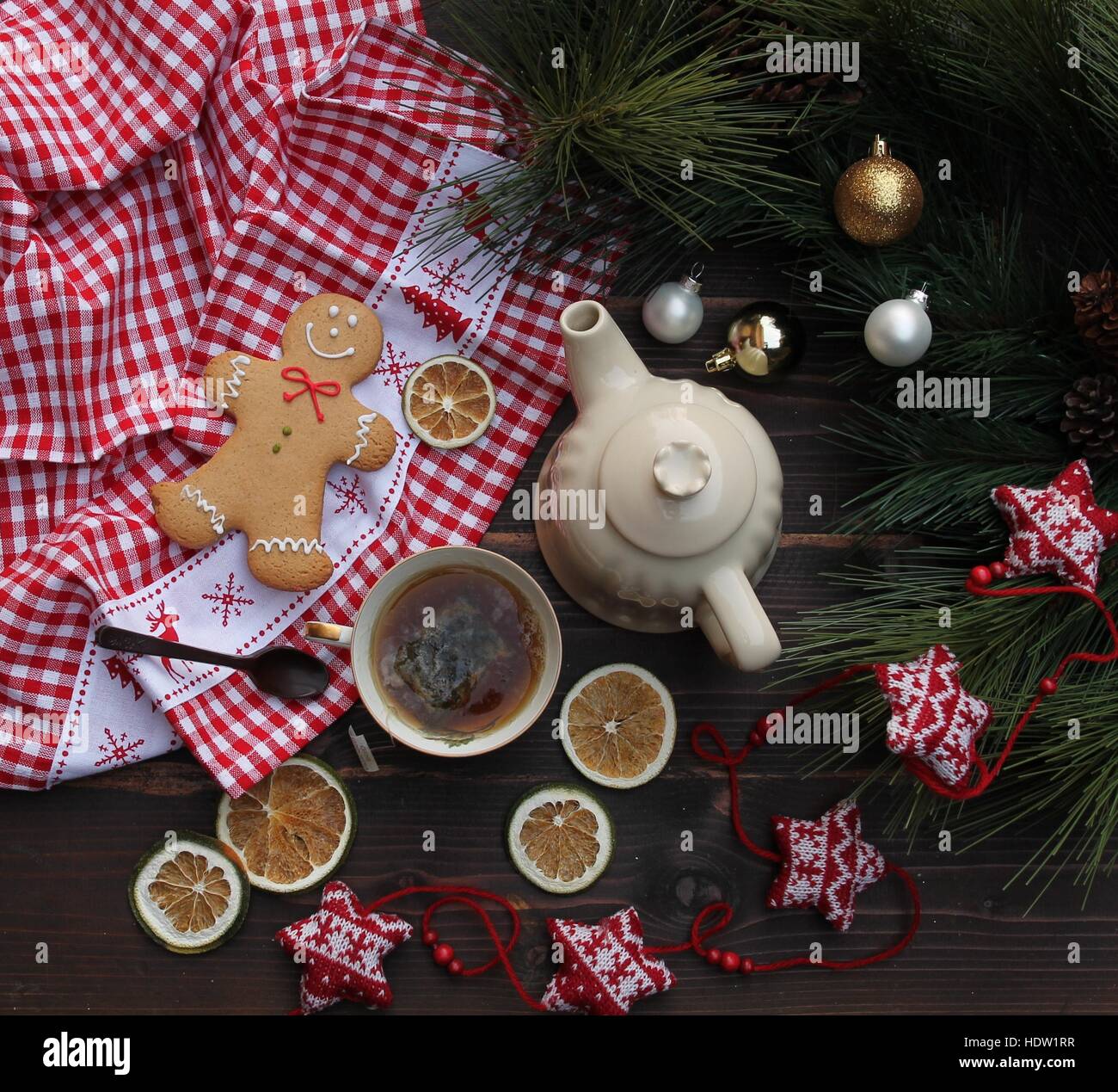 Christmas flatlay with gingerbread, green tea, lemon slices, Christmas decorations, a chocolate spoon and a gingham placemat Stock Photo