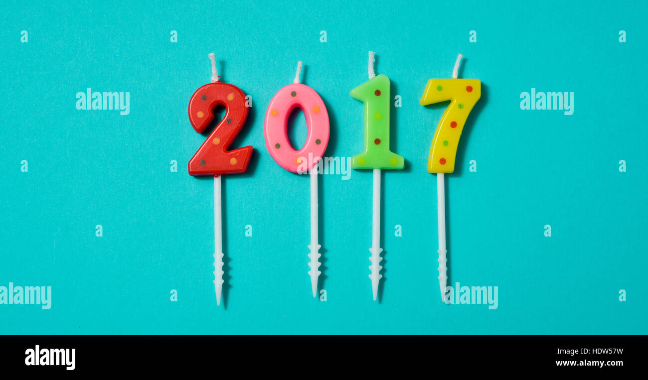 high-angle shot of some number-shaped candles of different colors forming the number 2017, as the new year, on a bright blue background Stock Photo