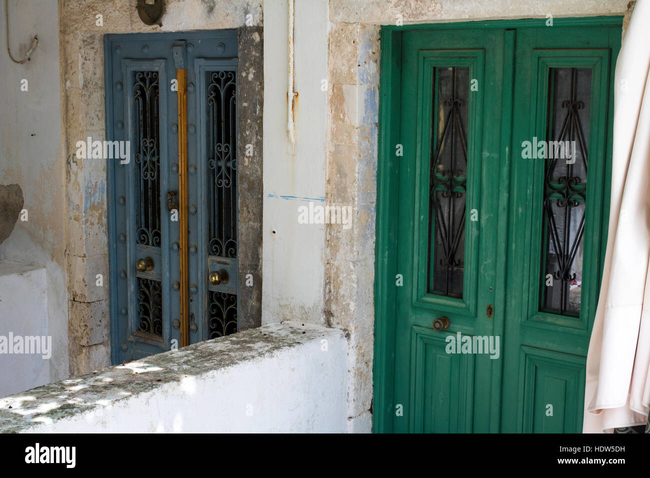 Detailed View, Two Wooden Doors with ornate Metal Grills on the Windows, Fiskardo, Kefalonia, Greece. Stock Photo