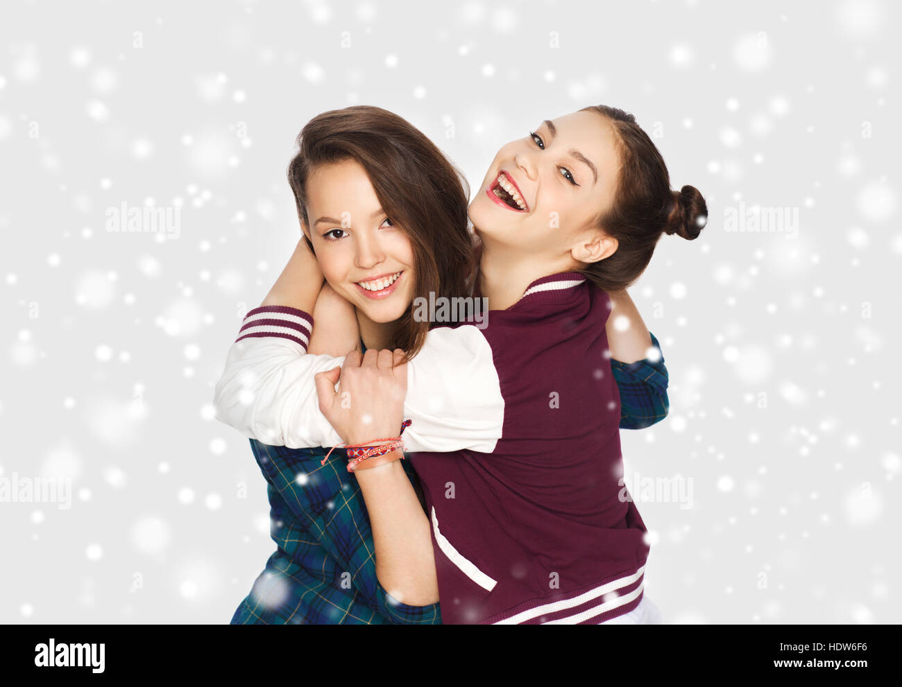 happy smiling teenage girls hugging over snow Stock Photo - Alamy