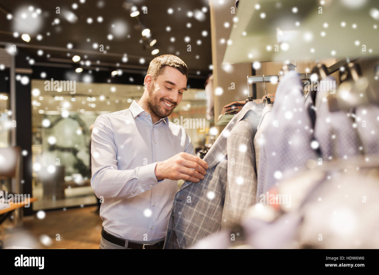 happy young man choosing clothes in clothing store Stock Photo - Alamy
