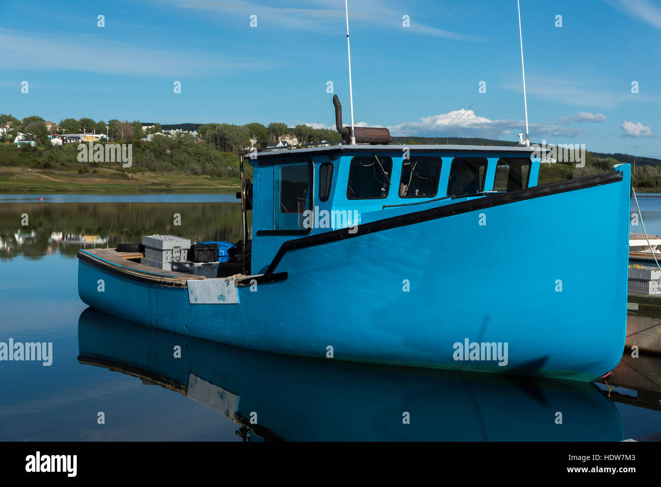 Blue boat moored against a dock in Inverness Harbour; Mabou, Nova Scotia, Canada Stock Photo