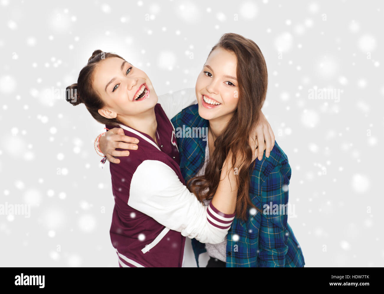 happy smiling teenage girls hugging over snow Stock Photo - Alamy