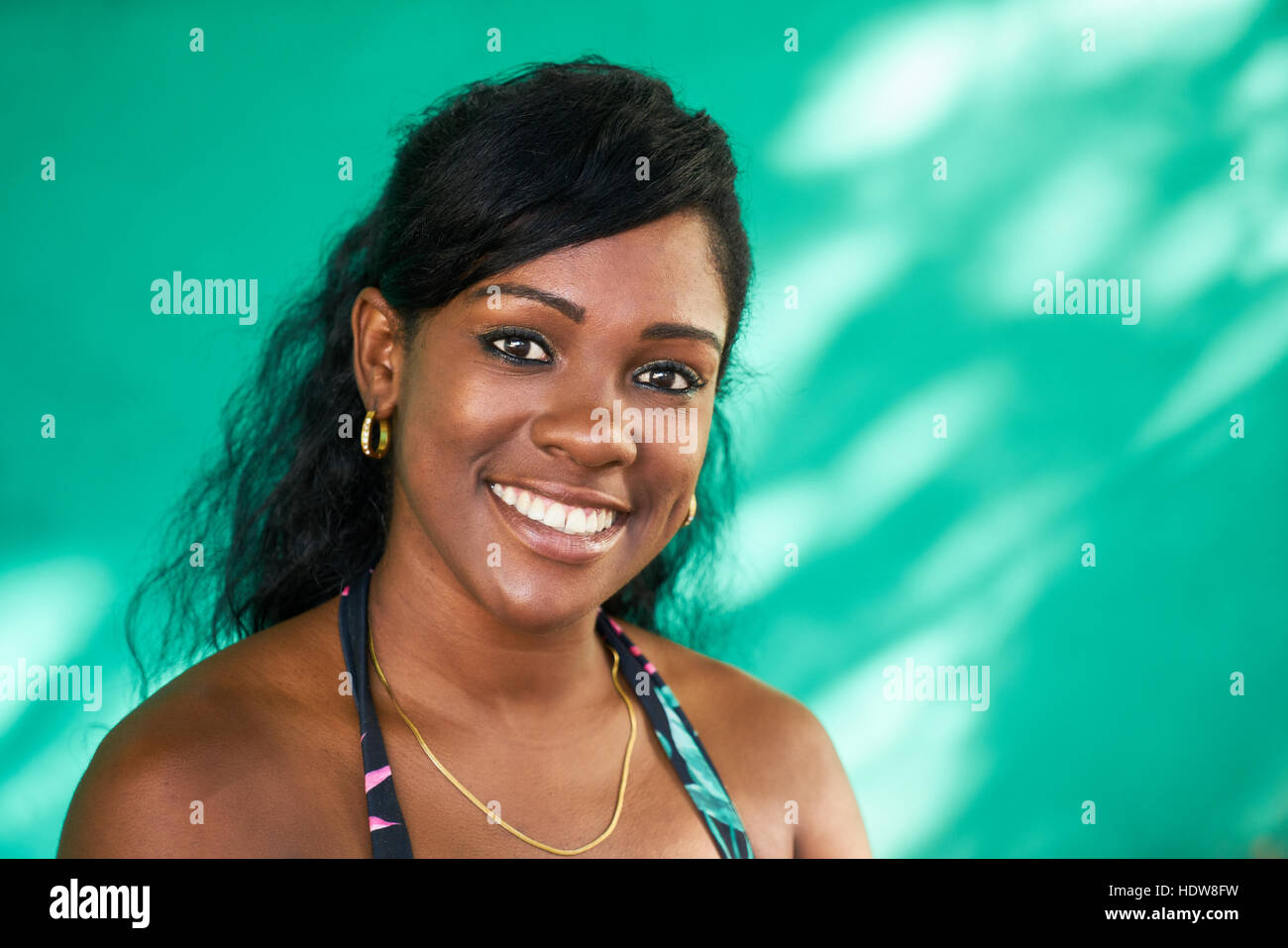 Portrait of Cuban girl with emotions and feelings. Black young woman from Havana, Cuba, smiling and looking at camera with joyful and funny smile. Stock Photo