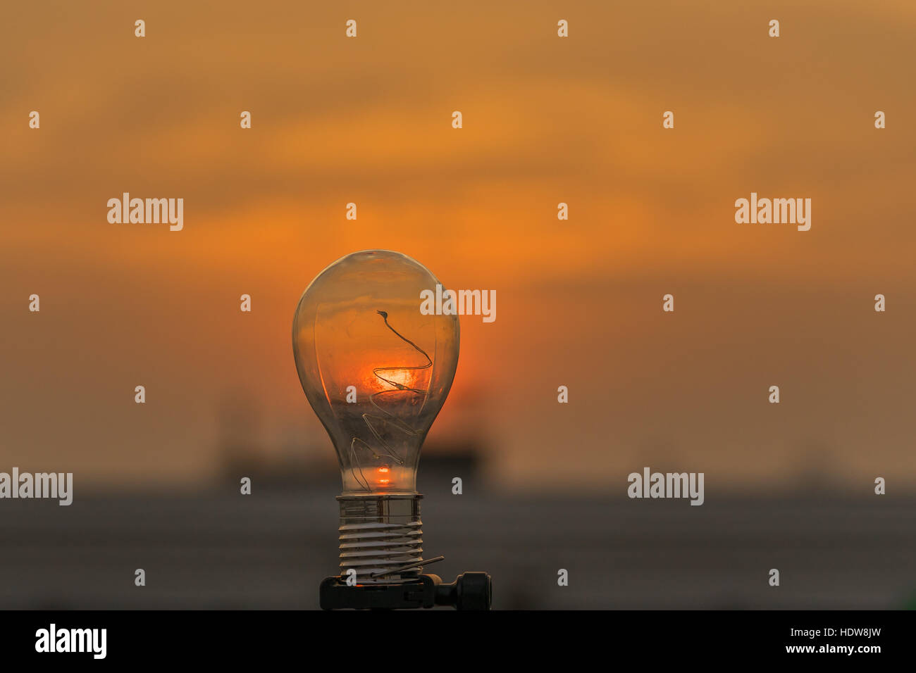 Bright idea, light bulb and sunset sky. Stock Photo