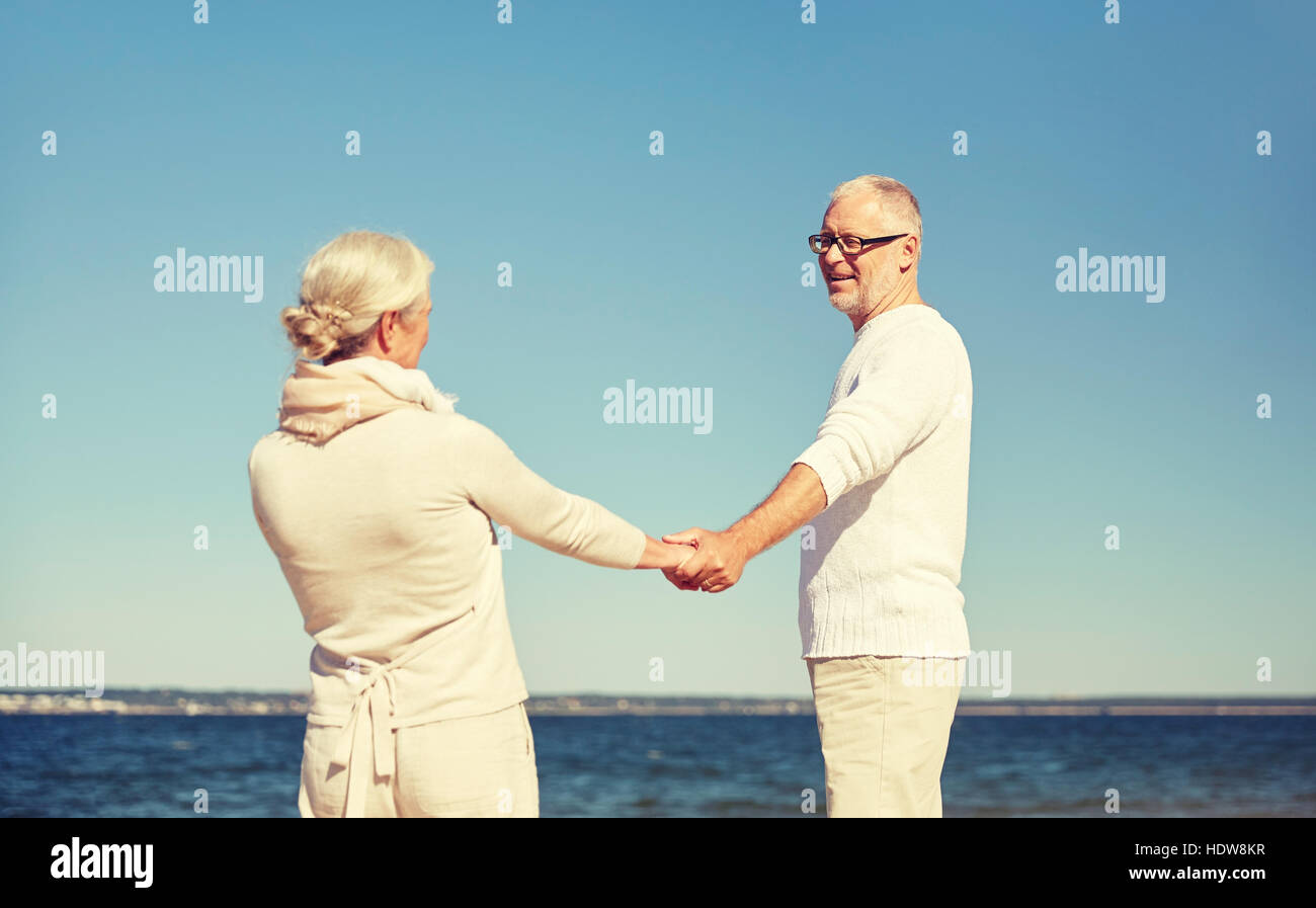 happy senior couple holding hands summer beach Stock Photo - Alamy