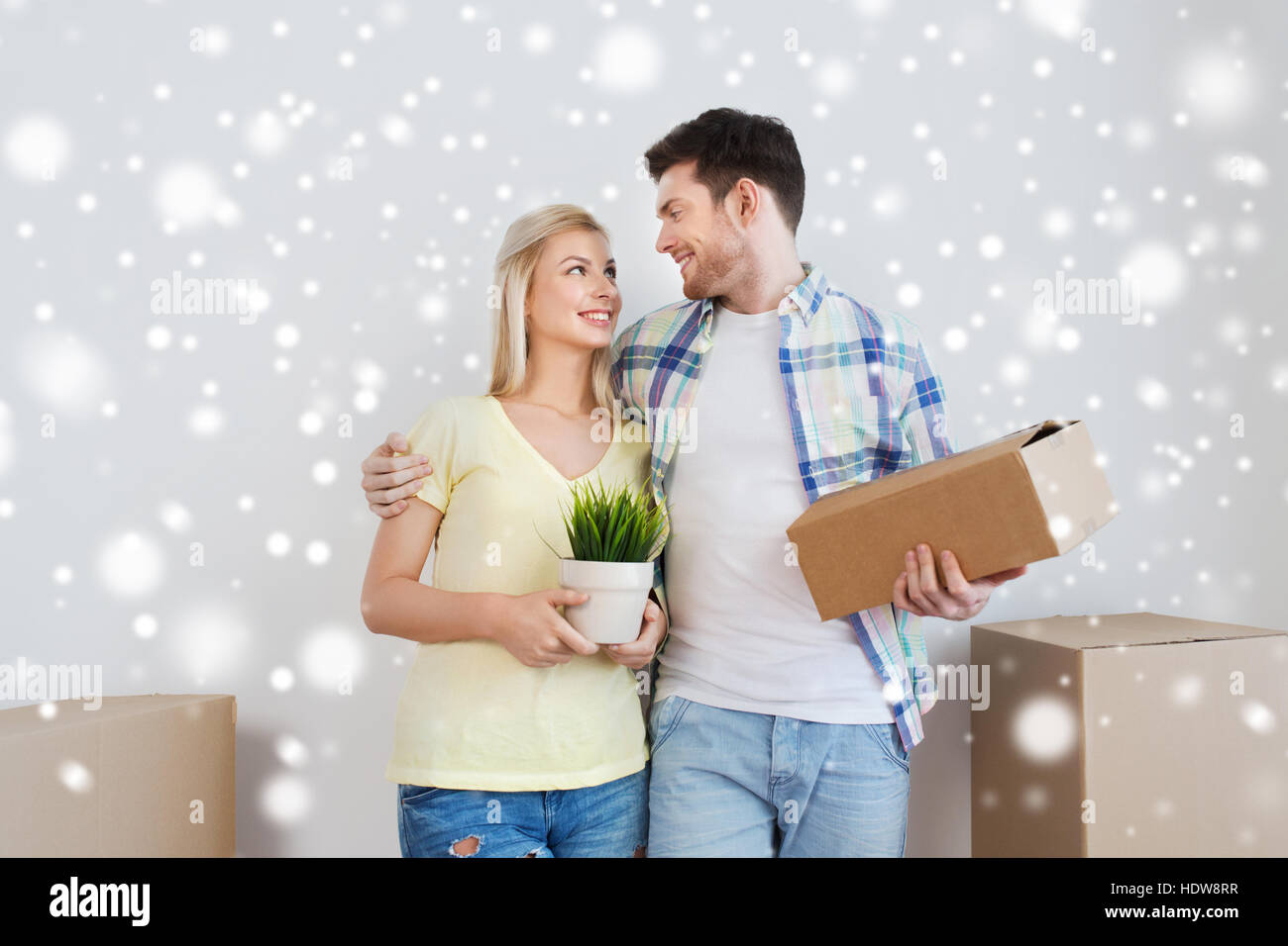 smiling couple with boxes moving to new home Stock Photo - Alamy