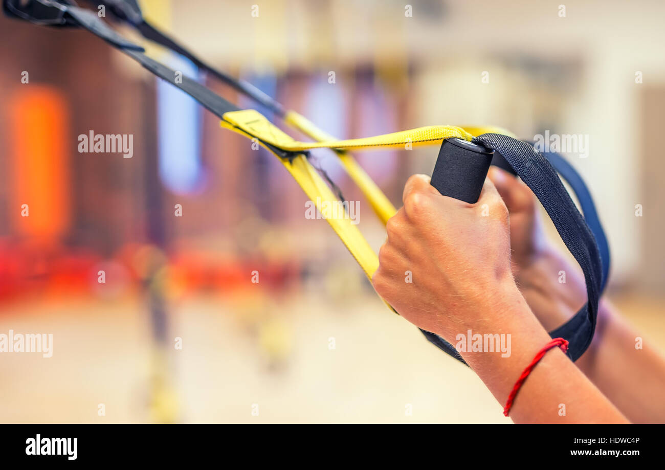 TRX. Female hands with fitness TRX straps in gym Stock Photo Alamy