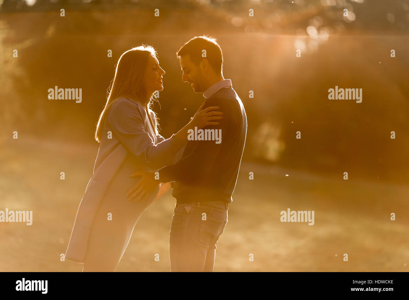 Pregnant woman and man posing at autumn park Stock Photo - Alamy