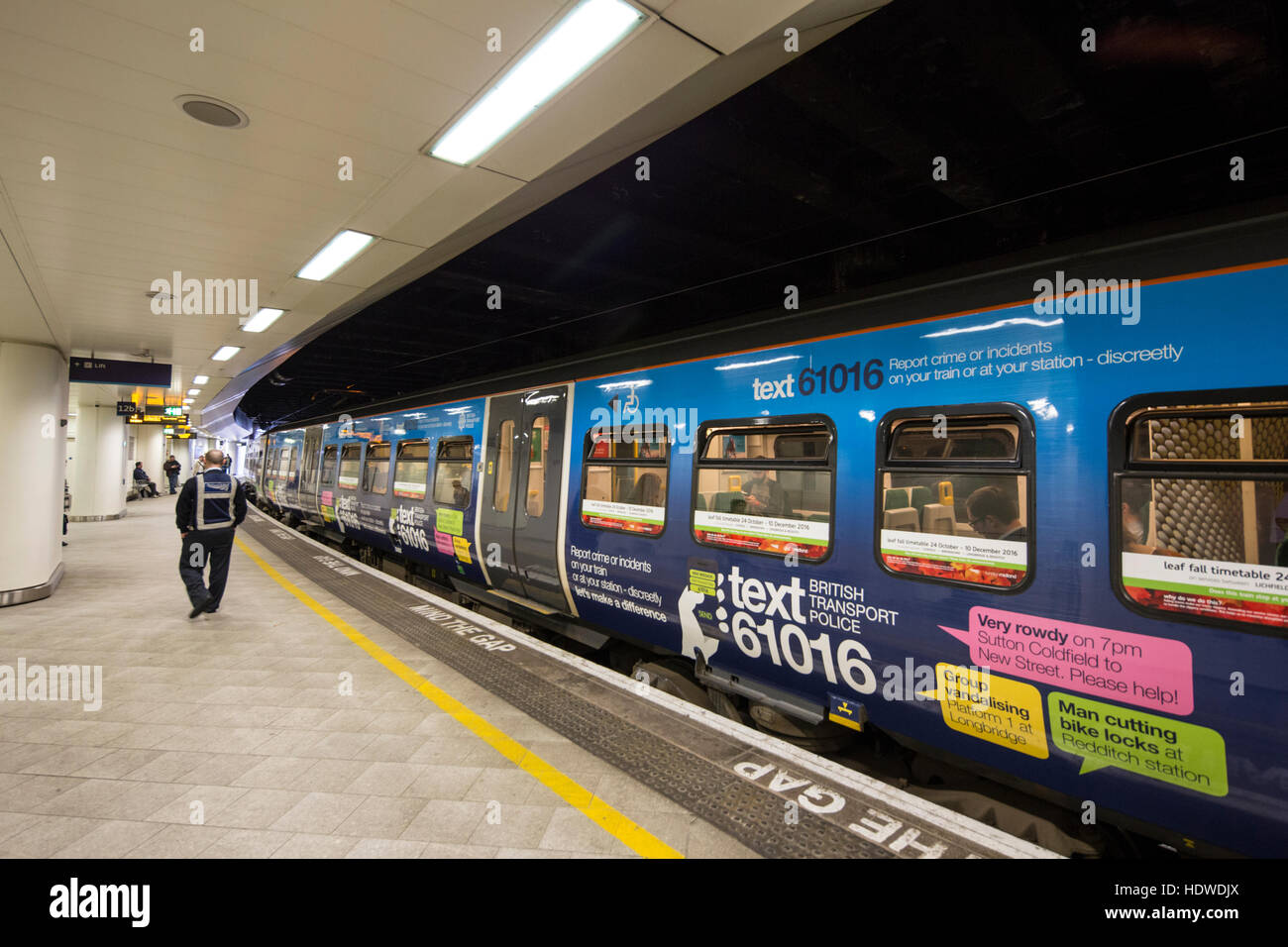 A train in New St Station with livery asking the public to report crime via a text message. Birmingham, England, UK Stock Photo