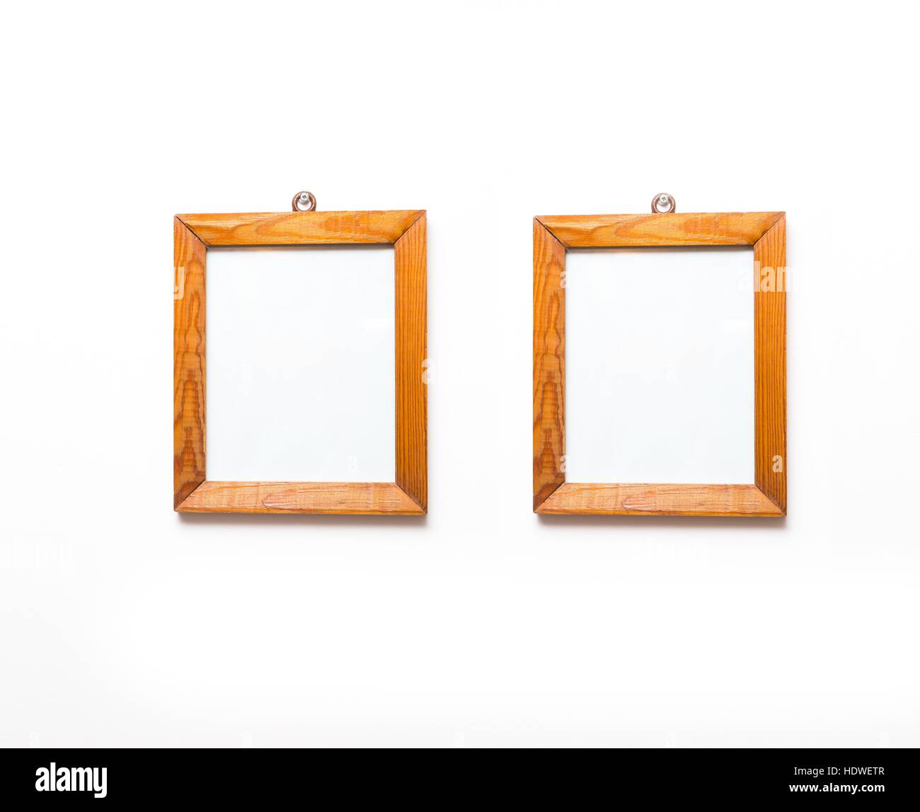 2 old wooden frames of pine wood hanging on white wall background. Wooden frame on white wall