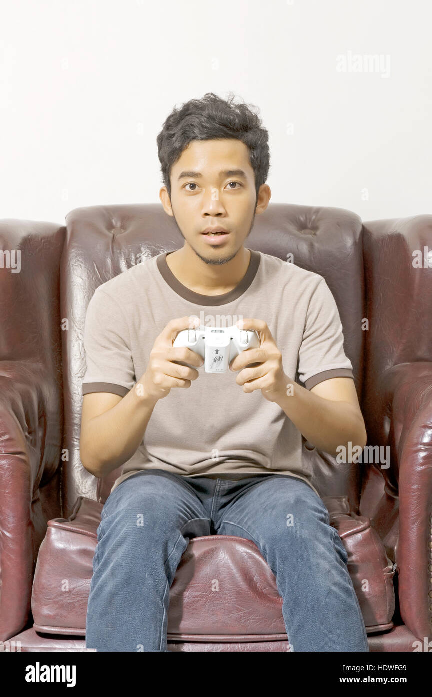 Young male playing video game on the couch on living room Stock Photo