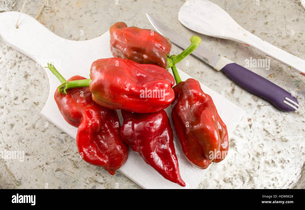 red bell peppers on a white cutting board Stock Photo