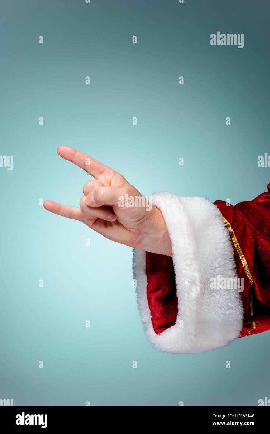 Photo of Santa Claus hand in rocker gesture on blue Stock Photo - Alamy
