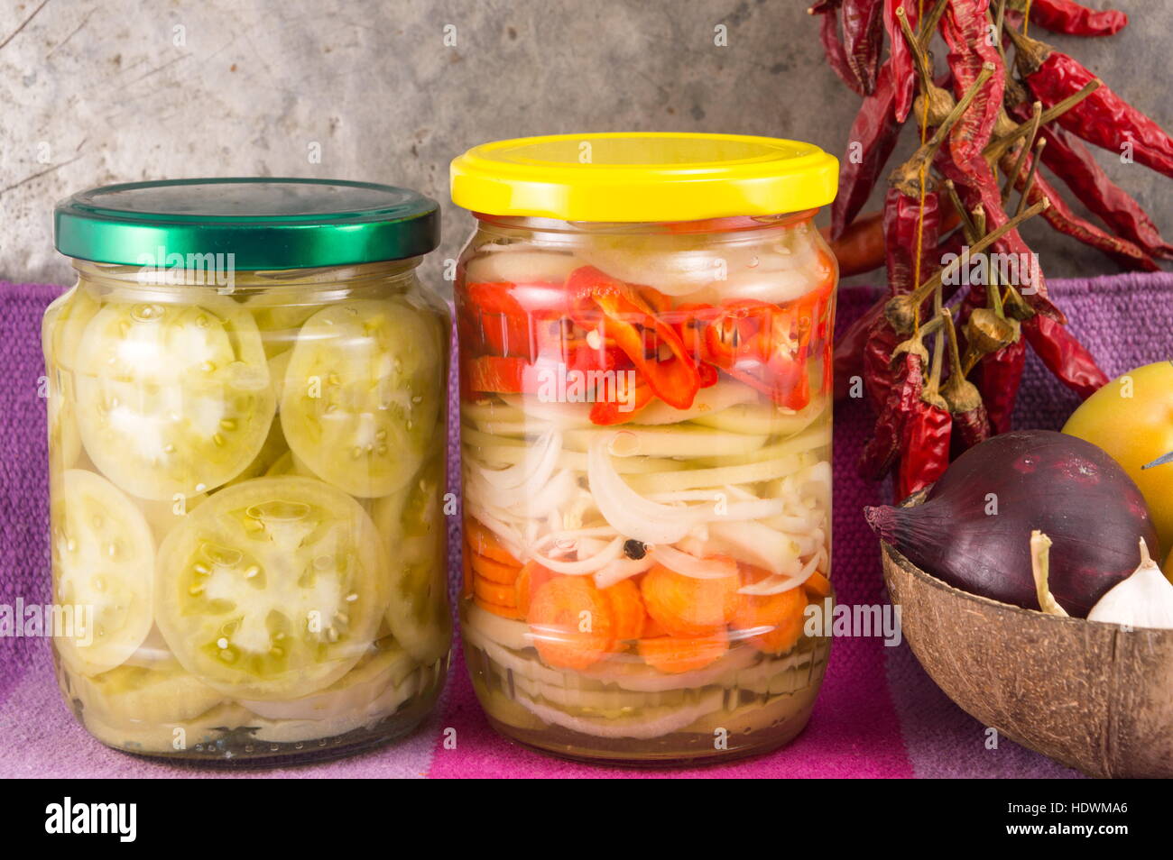 pickeled vegetables in a jar with onions and dried peppers Stock Photo