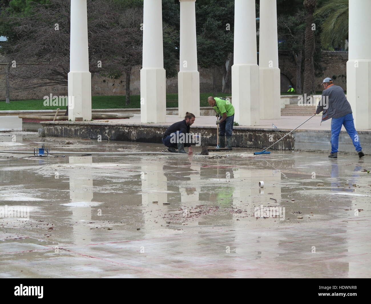 Men carrying out pond maintenance in winter in park in Valencia, Spain Stock Photo