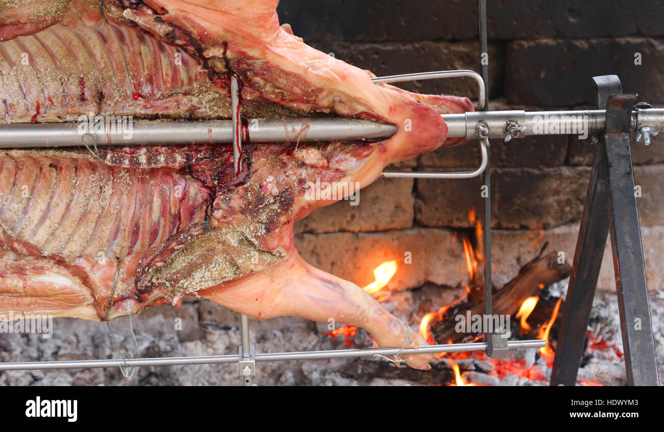 big fat pork cooked on a spit during a village festival Stock Photo