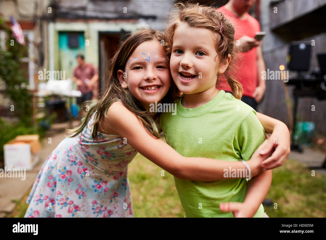 Caucasian girls hugging at backyard party Stock Photo