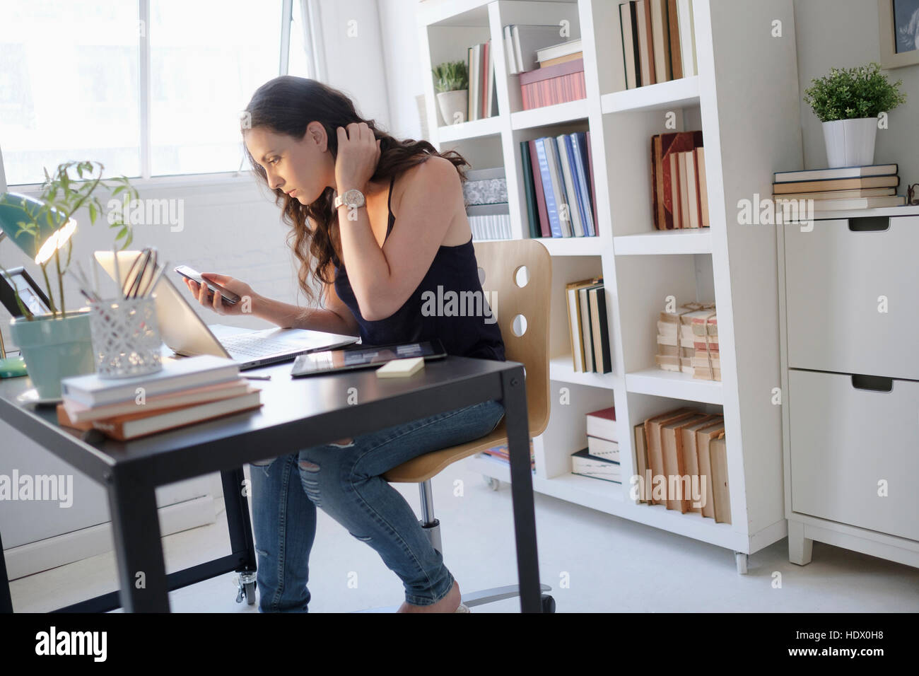 Hispanic businesswoman using technology in office Stock Photo