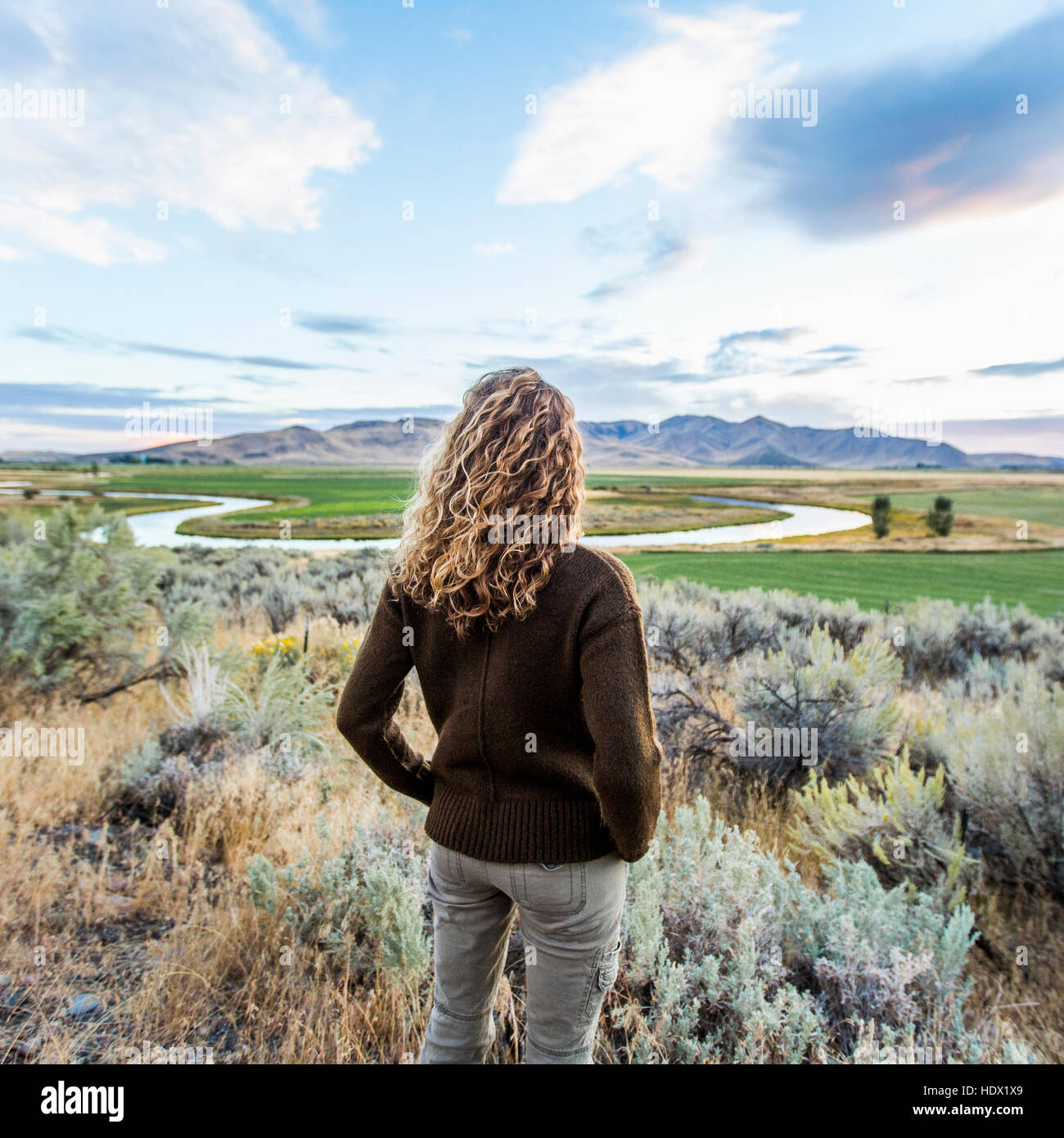 Caucasian woman standing near winding river Stock Photo - Alamy