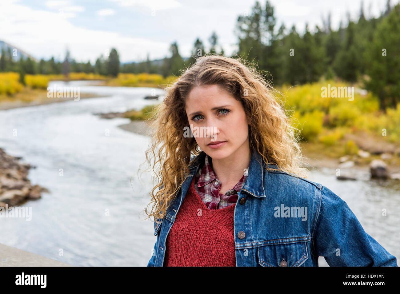 Serious Caucasian woman standing near winding river Stock Photo - Alamy