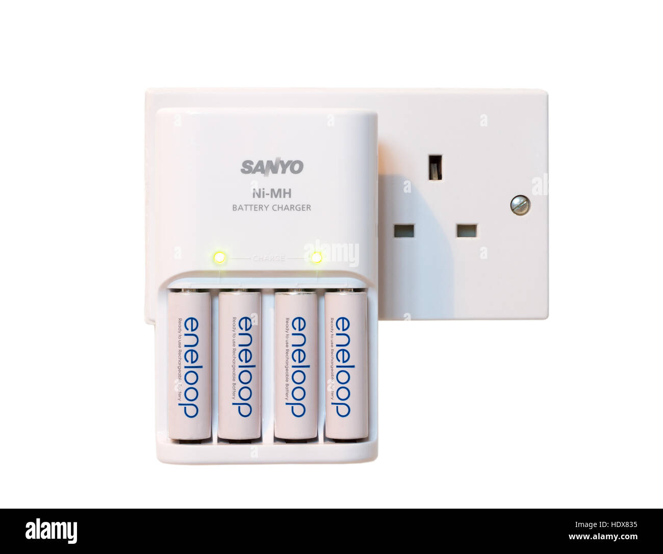 Sanyo eneloop Ni-Mh rechargeable batteries being charged from a mains double socket isolated on a white background Stock Photo