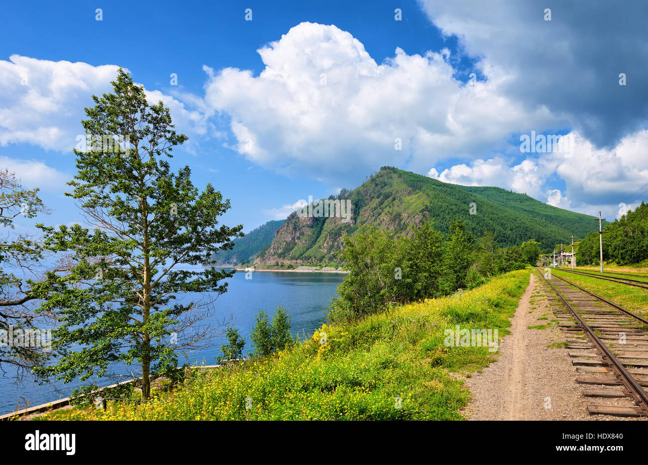 Circum-Baikal Railway, poplars on shore of Lake Baikal and high hill in half overgrown with forest in background Stock Photo
