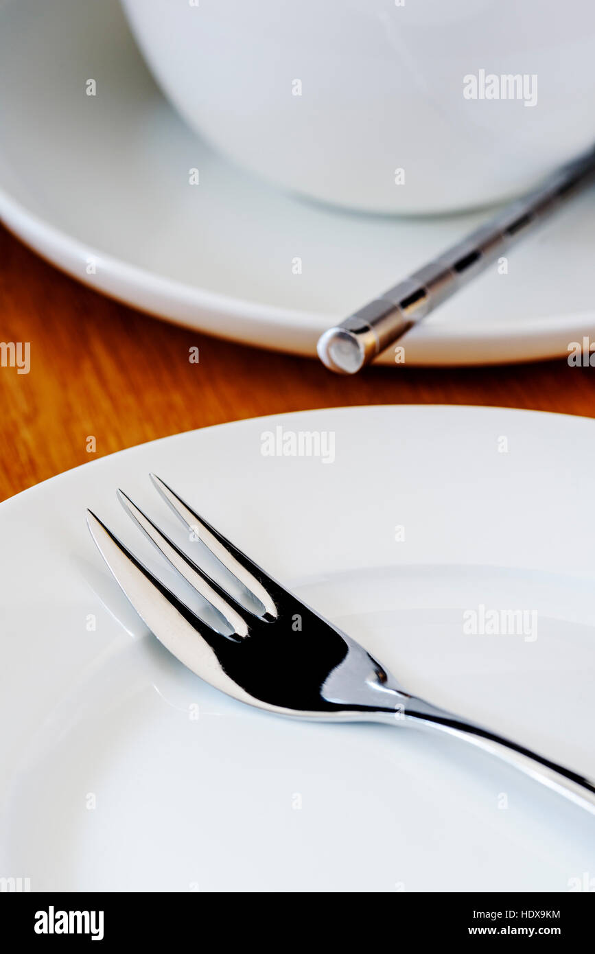 Tea set laid ready for afternoon tea. Table set out with white porcelain tea set. Stock Photo