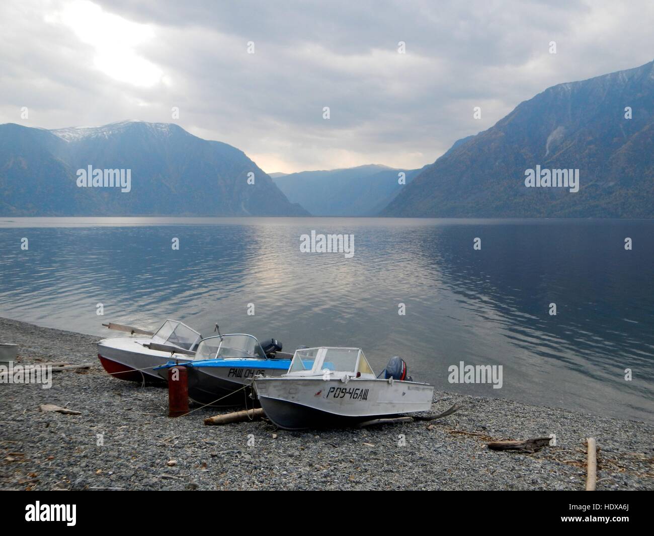 Fishing boats on bled lake pebble beach Stock Photo - Alamy