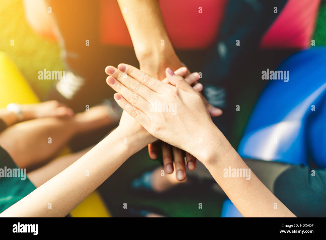 Three young business people joining hands team up, teamwork or unity concept, multi-ethnic diversity group, warm light and depth of field effect Stock Photo