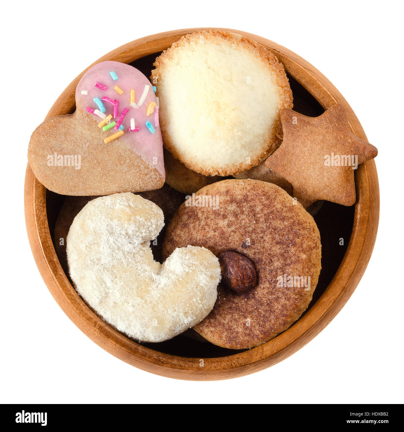 Cookies and biscuits in wooden bowl. Assorted flat sweet baked goods in heart, crescent, star and disc shapes. Stock Photo