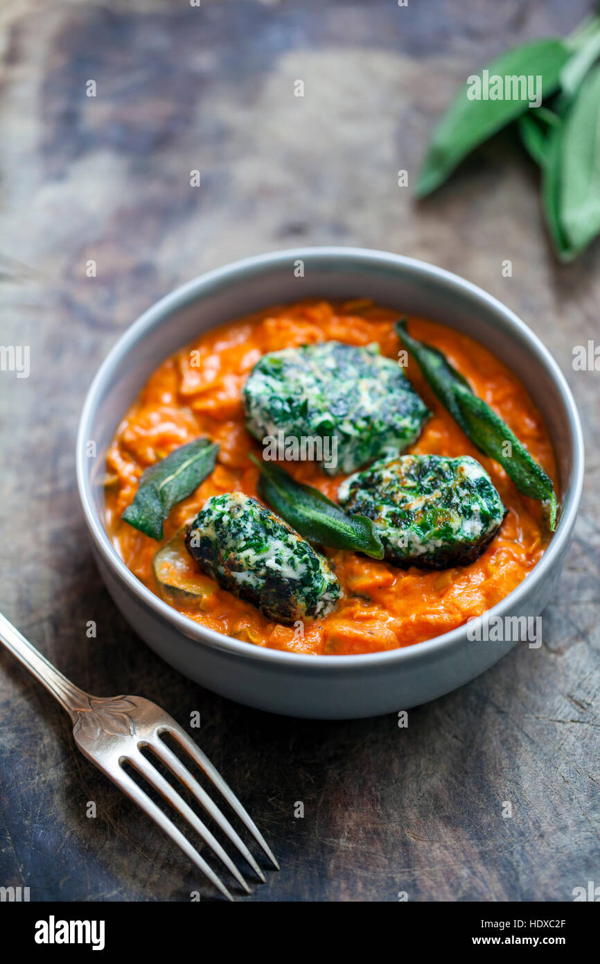 Spinach and ricotta dumplings in tomato and courgette sauce Stock Photo