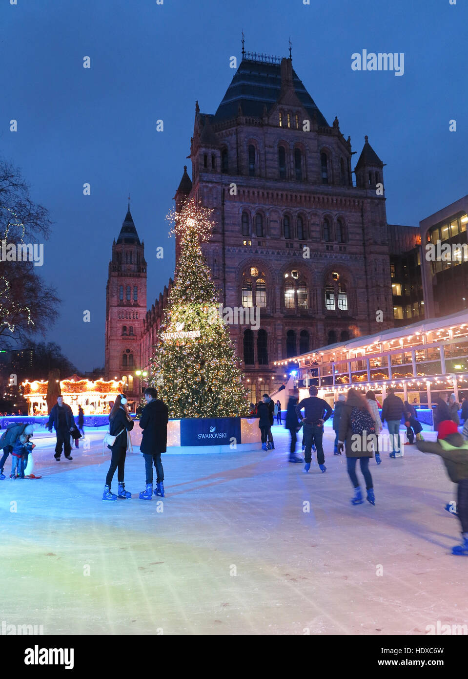 Skaters on ice rink in front of the Natural History Museum at Christmas time. Stock Photo