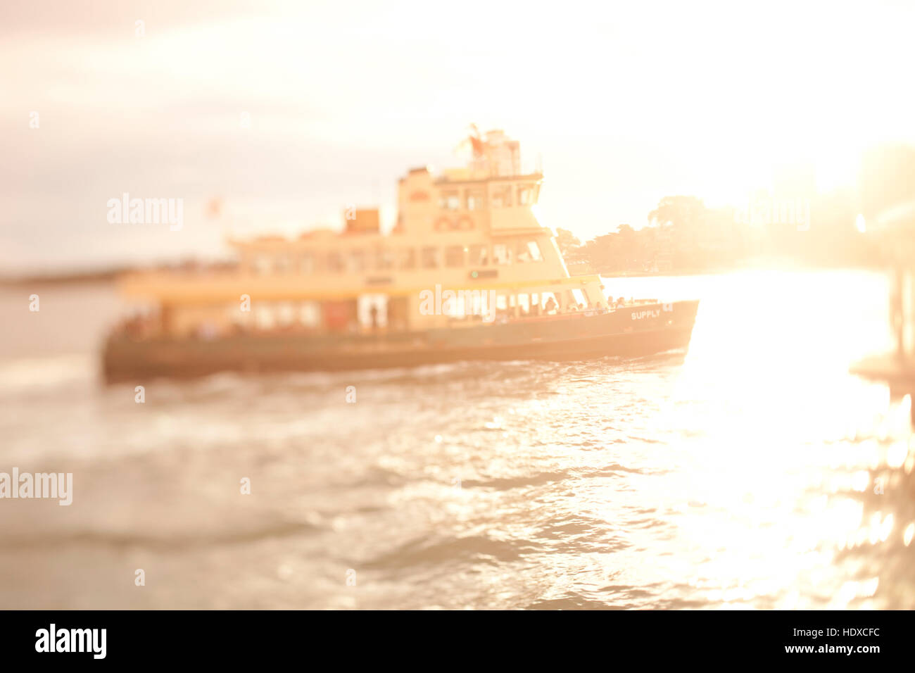 Select focus tilt-shift image of harbor ferry in Sydney Harbor during sunset Stock Photo