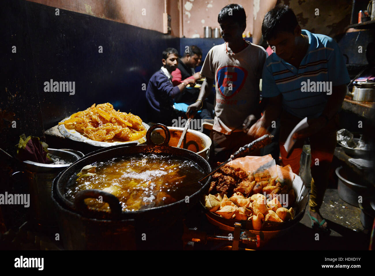 fresh Jalebi sweet snack deep fried by a cook in a small sweet stall in Jorhat, India. Stock Photo