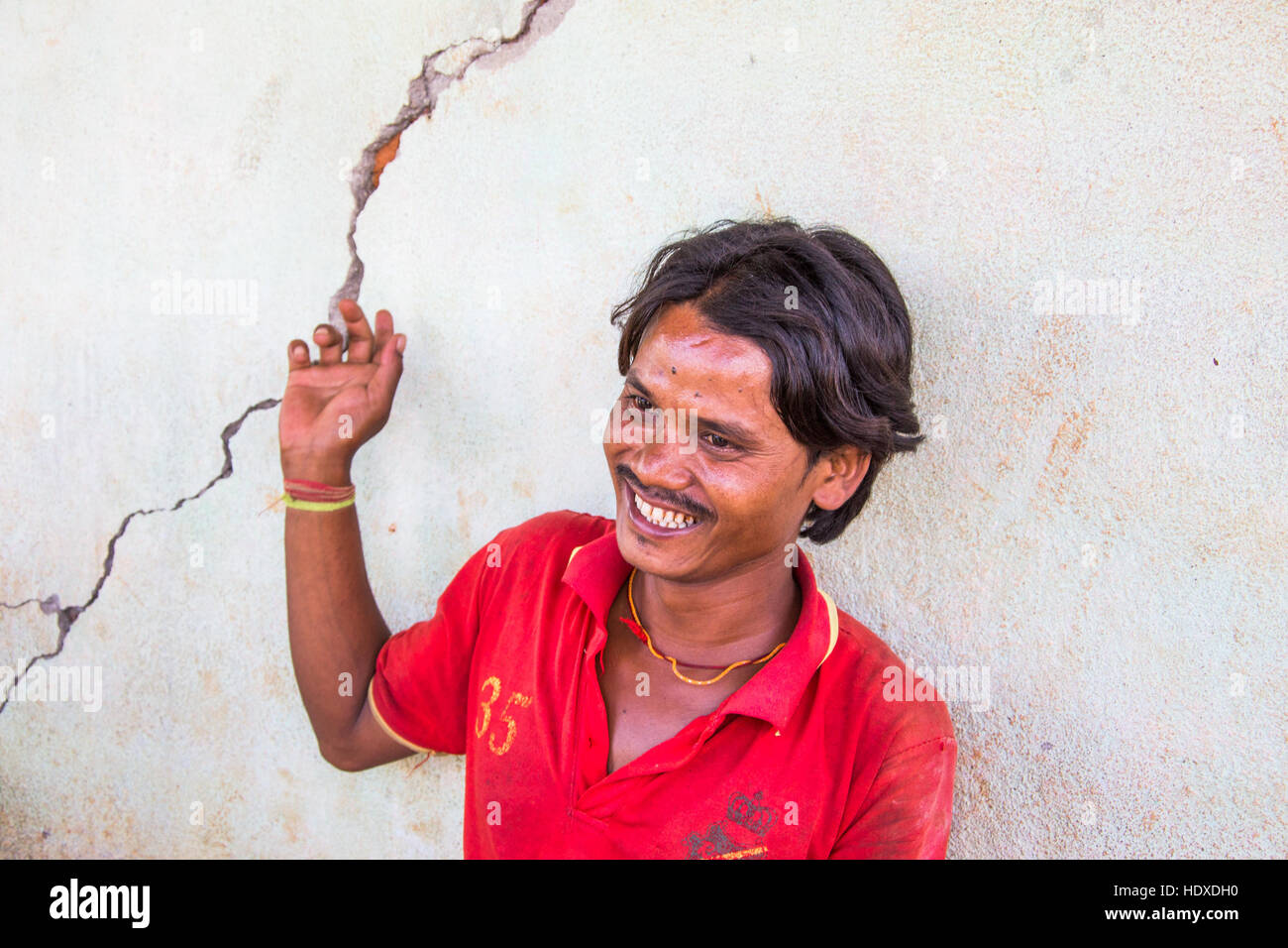 Man pointing out an earthquake caused crack in his house in Nuwakot ...