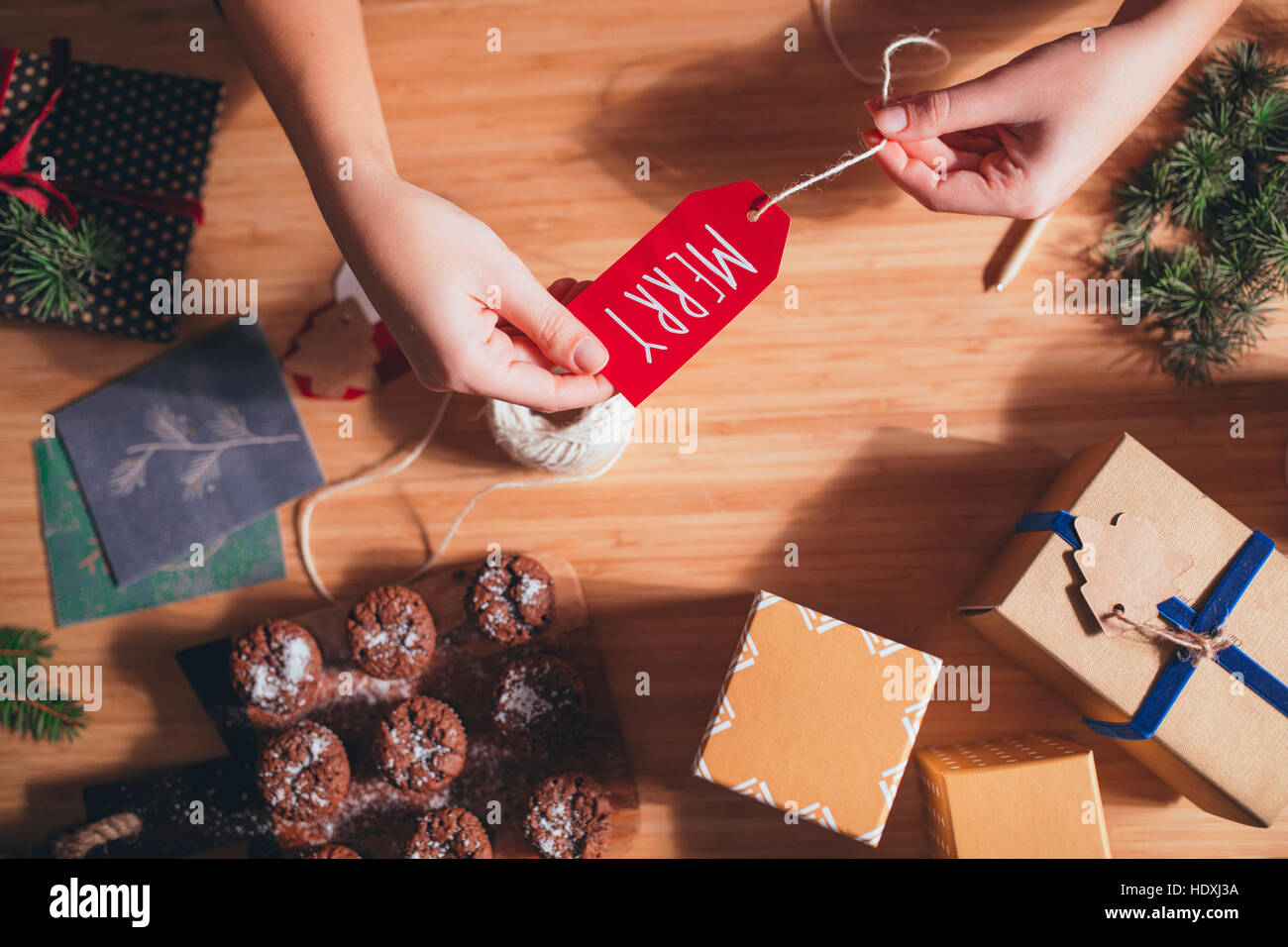 Woman wrapping and decorating Christmas present Stock Photo