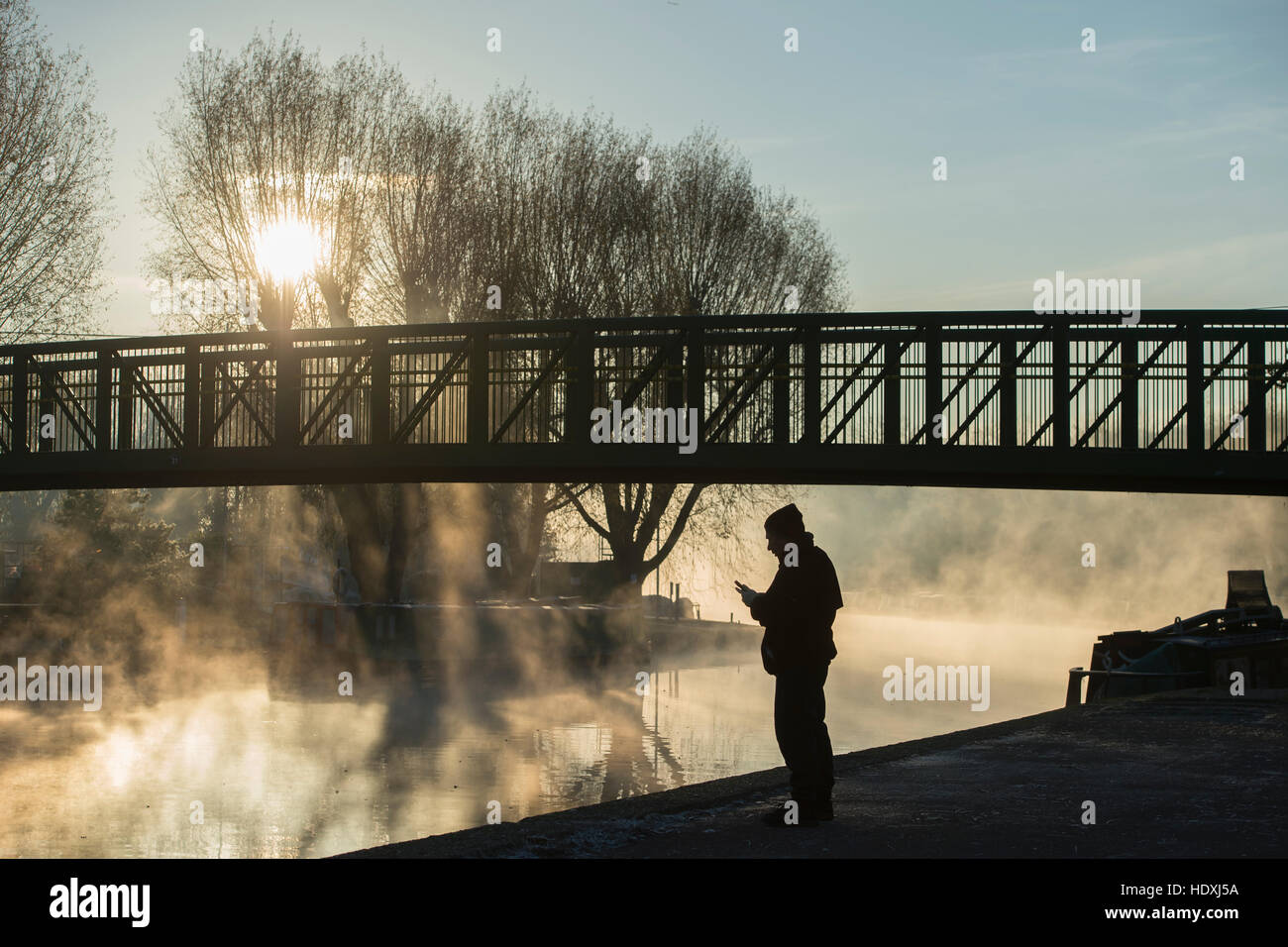 30th November, 2016. London, UK.  A man looks at his phone by the River Lea in Tottenham, London, on a cold misty morning. Photo: David Mirzoeff/ Alam Stock Photo