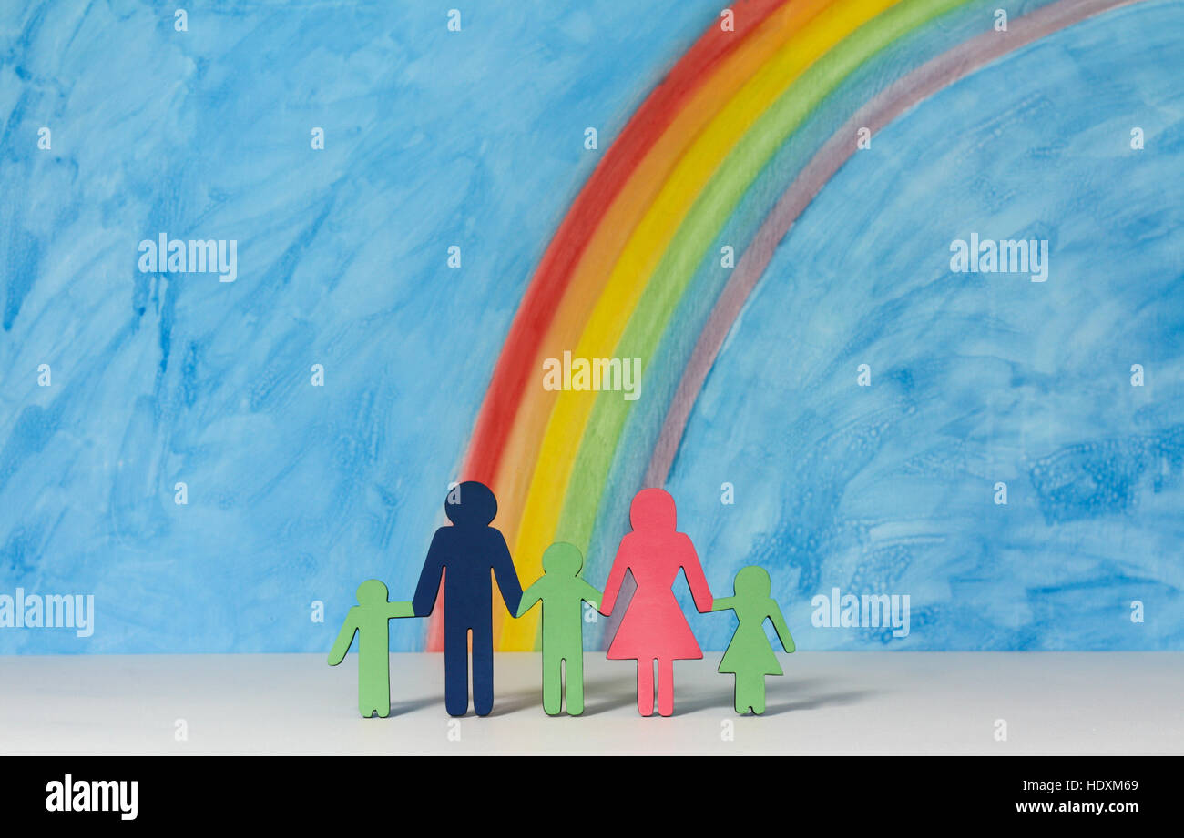 Father, mother and children icons with a rainbow and blue sky; illustrating the concept of traditional family; landscape format. Stock Photo