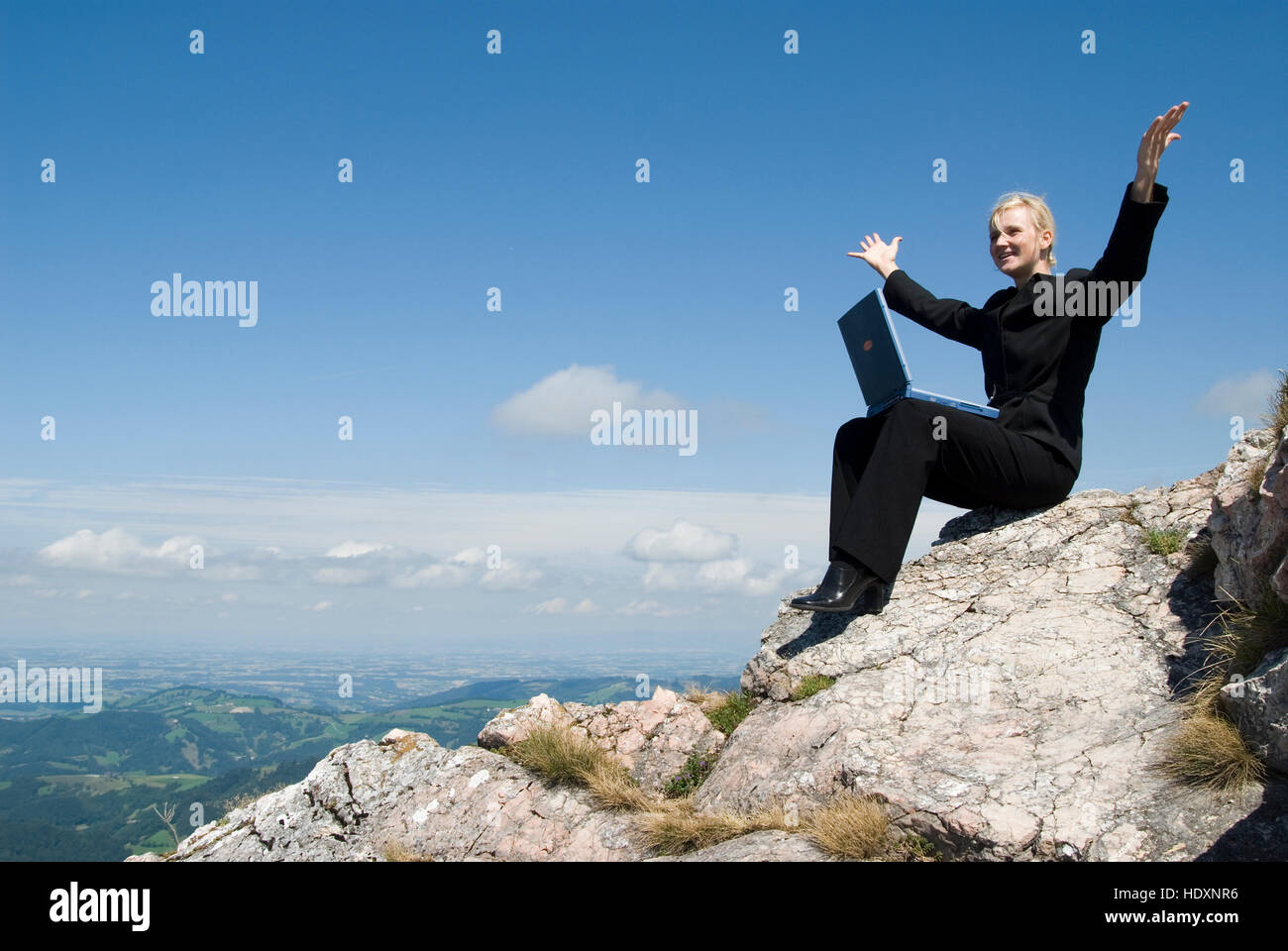 Businesswoman on a mountain peak with a laptop Stock Photo