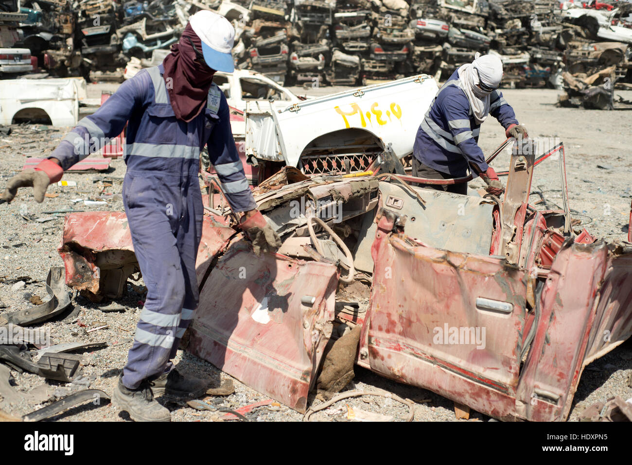 Migrant workers dismantle cars for recycling, UAE Stock Photo
