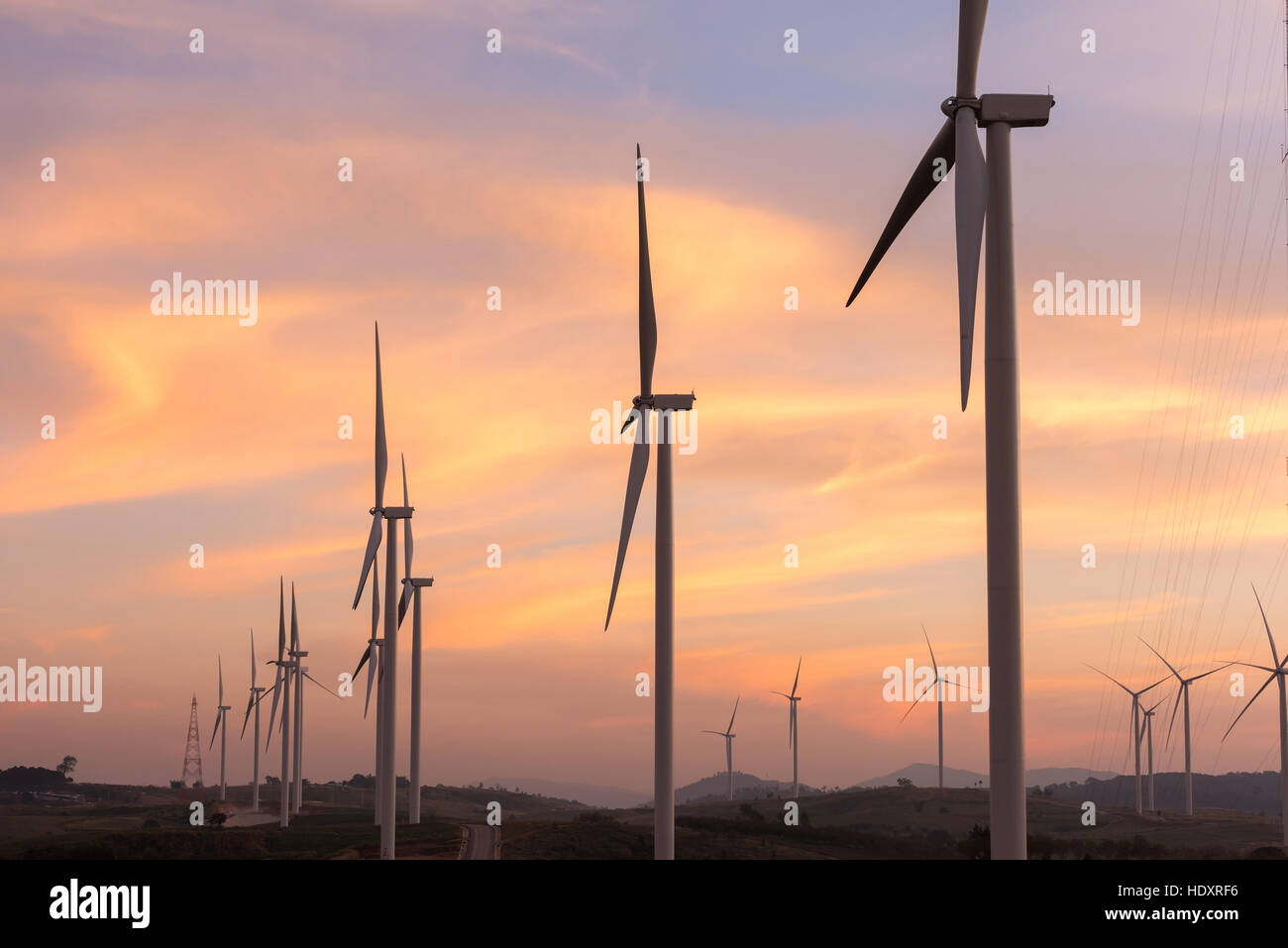Wind power generation,Wind turbines on farmland and agricultural countryside with sunset at Phetchabun Province,Thailand Stock Photo