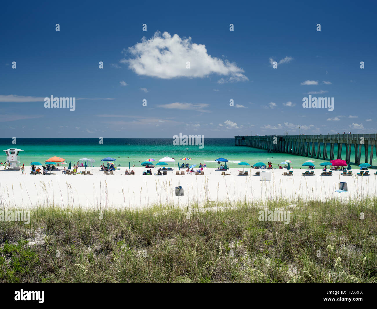 People enjoy the white sandy beach and turquoise waters at a Gulf Coast beach in Florida. Stock Photo