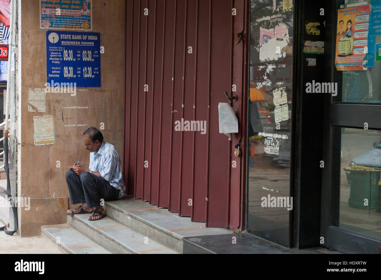 Man waiting in front of a bank to open, Bangalore, India (photo taken before demonetization 2016) Stock Photo