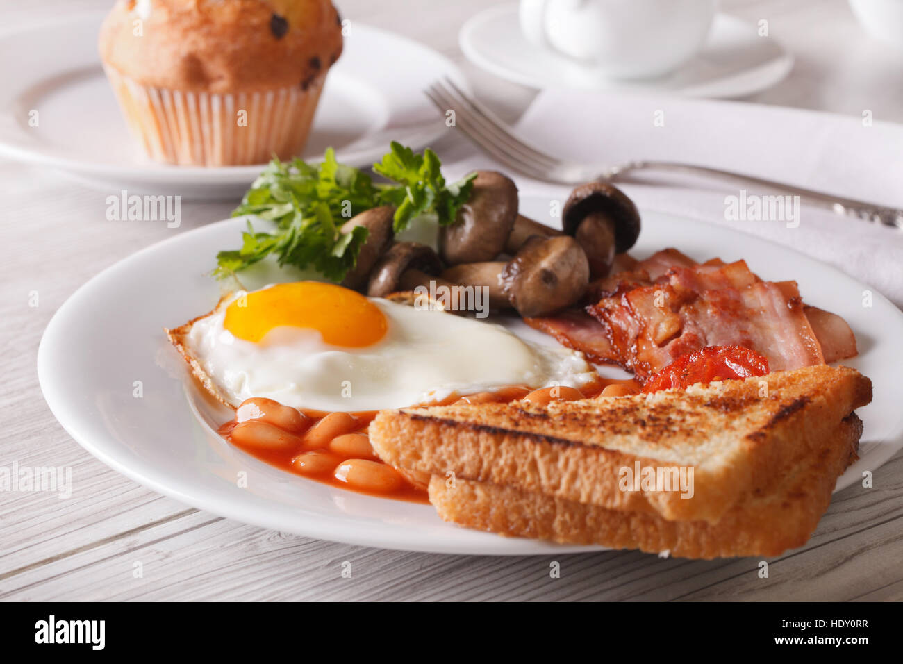 Fried egg with bacon and beans on a plate close-up. horizontal Stock Photo