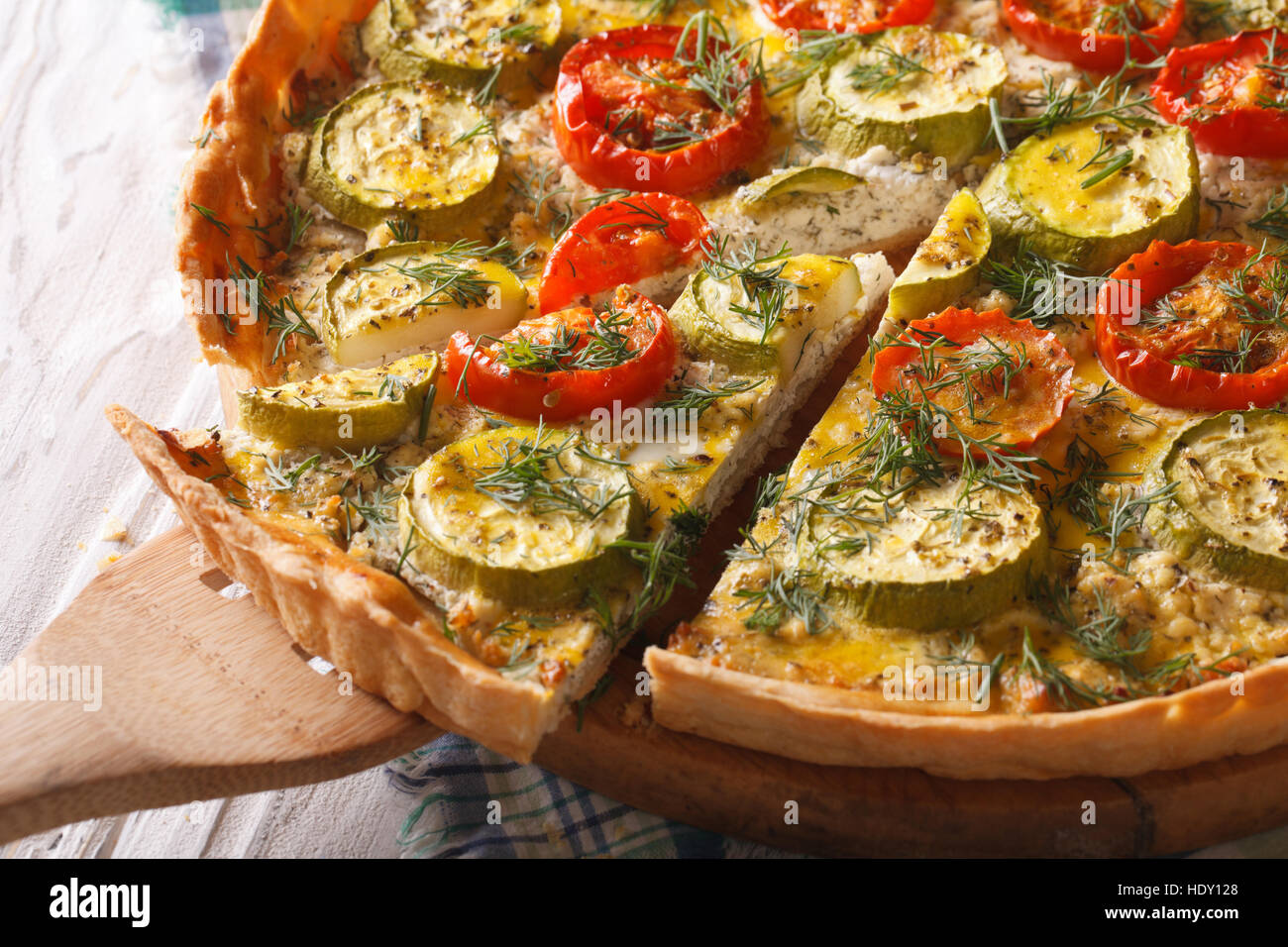Sliced vegetable tart with cheese tomatoes and zucchini closeup. horizontal Stock Photo