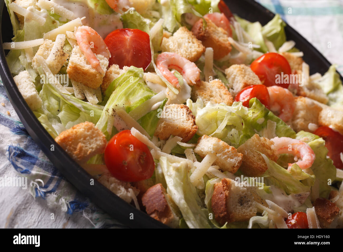 Caesar salad with shrimp and tomatoes close-up on a plate. horizontal Stock Photo