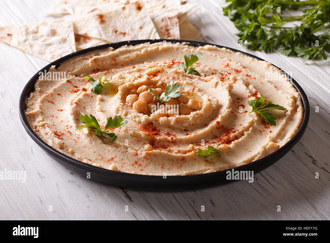 Vegetarian hummus with parsley on the plate close-up and pita bread. horizontal Stock Photo