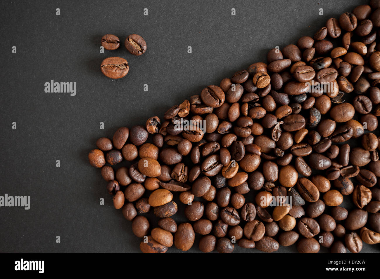 roasted coffee beans over black paper background Stock Photo - Alamy