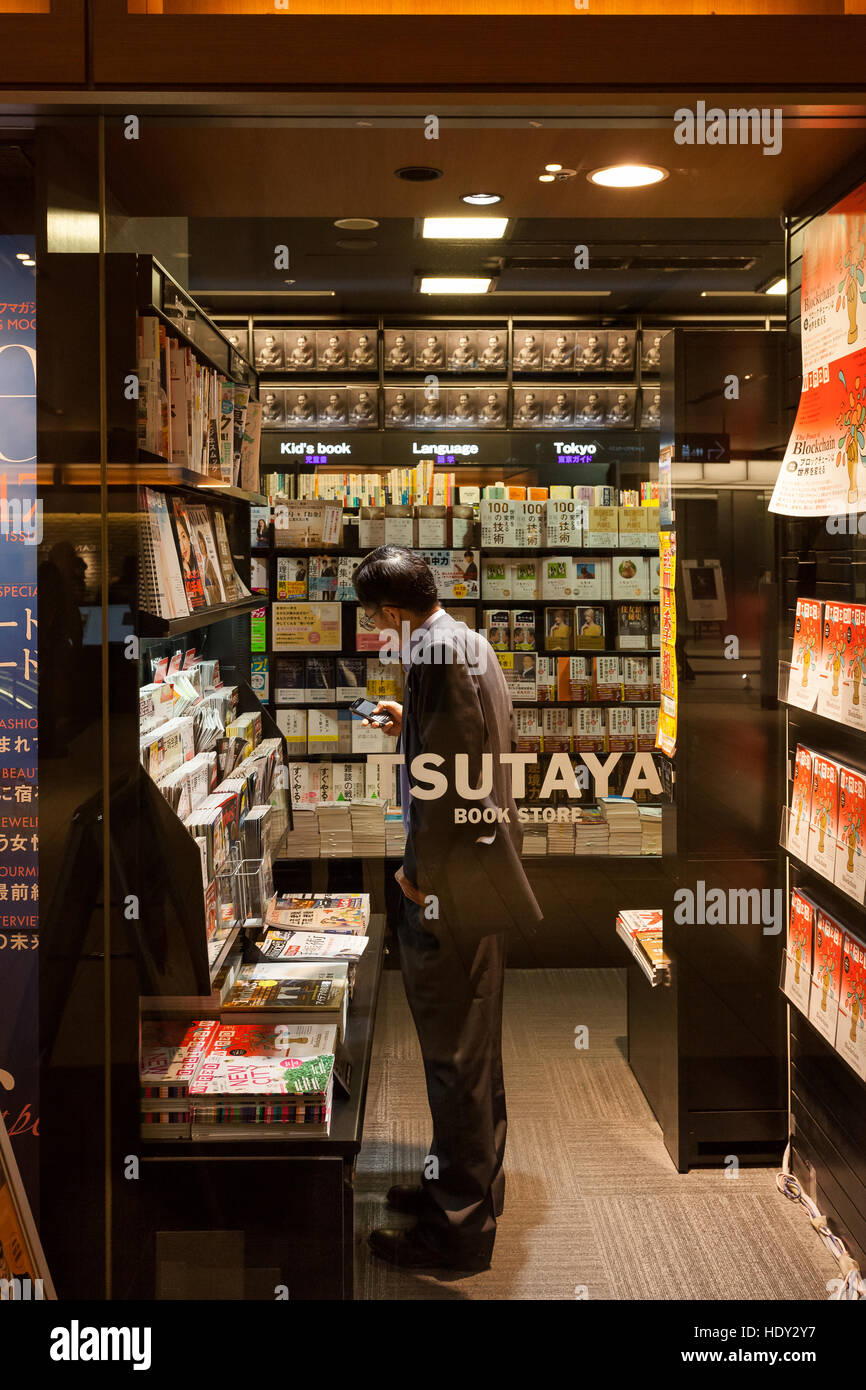A Japanese salaryman uses a smartphone inside Tsutaya